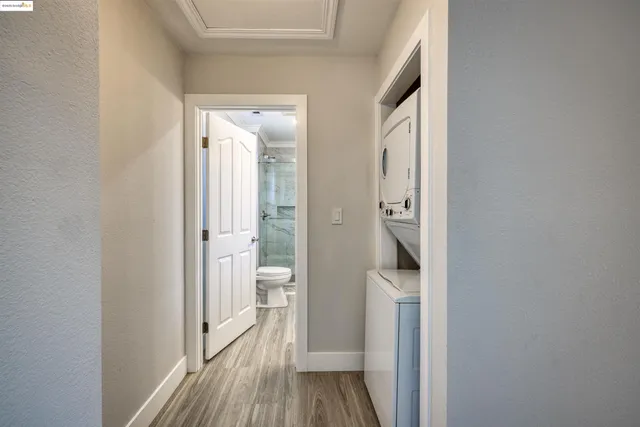 a walk in closet with wooden floor