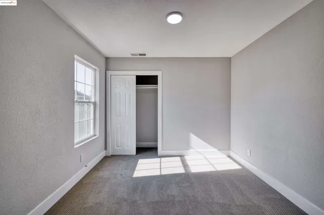 an empty room with windows and closet