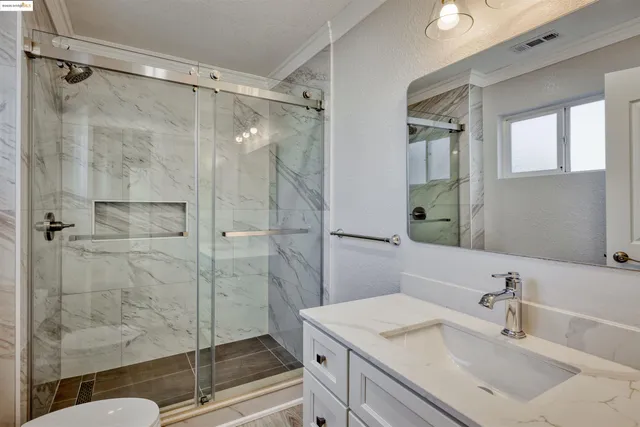 a bathroom with a sink shower and a mirror