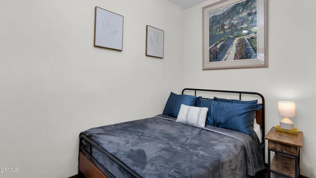 a bedroom with a bed and painting on the wall