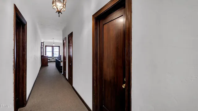 a view of a hallway with a livingroom and a bathroom with sink
