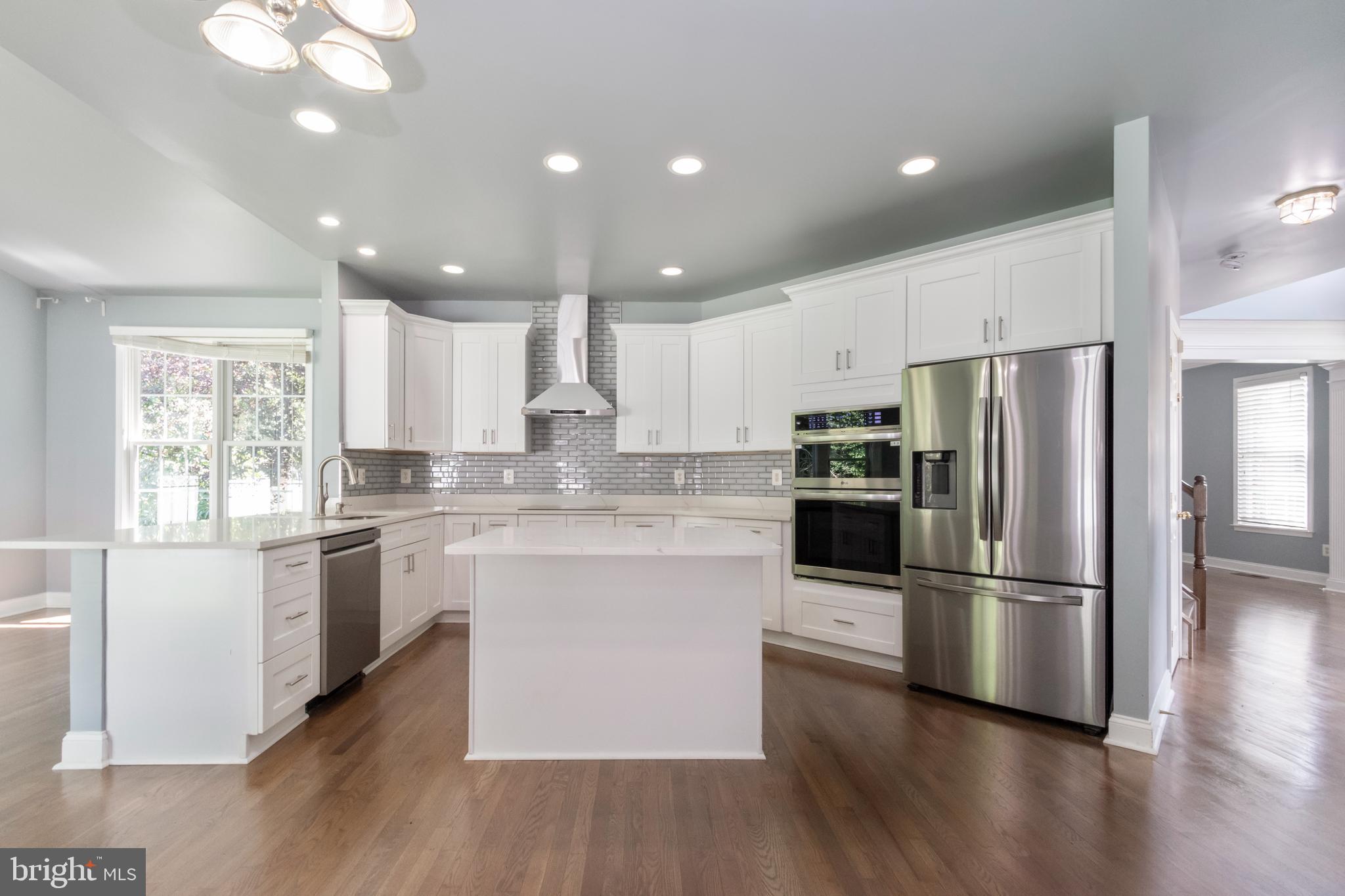 15 Johnson Road Pasadena, MD 21122 - Photo 17 of 40 a kitchen with stainless steel appliances granite countertop a refrigerator a sink dishwasher a stove and white cabinets with wooden floor