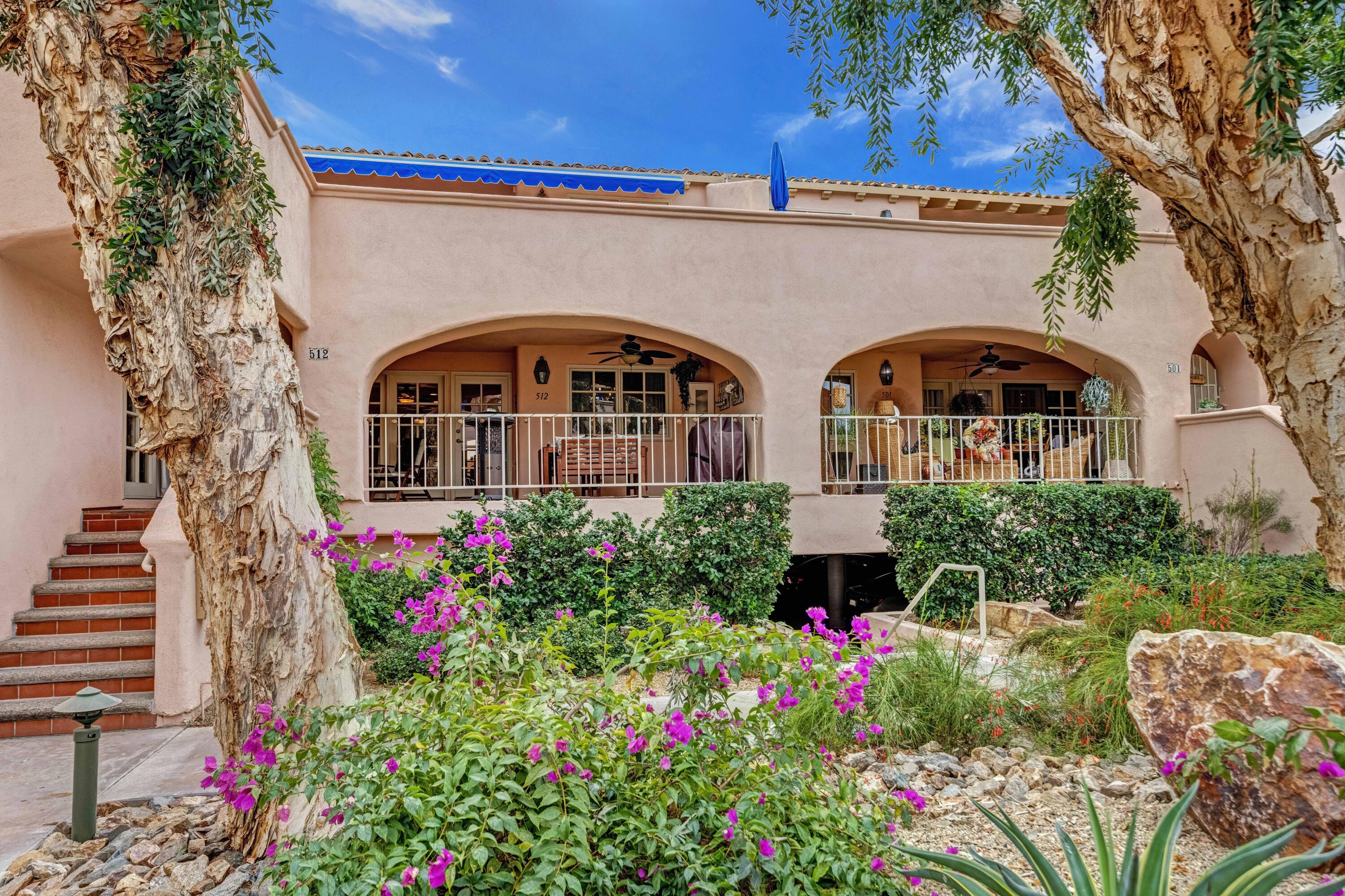 a front view of house and yard with beautiful flowers and green space