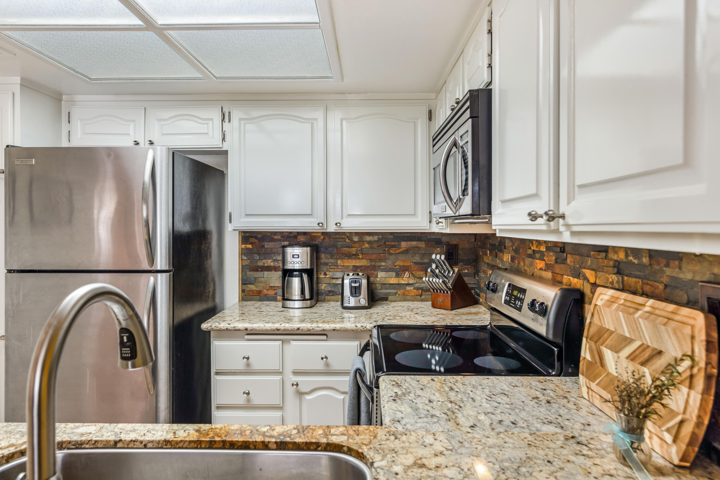 500 East Amado Road, Unit 512 Palm Springs, CA 92262 - Photo 11 of 37 a kitchen with stainless steel appliances granite countertop a refrigerator sink and cabinets