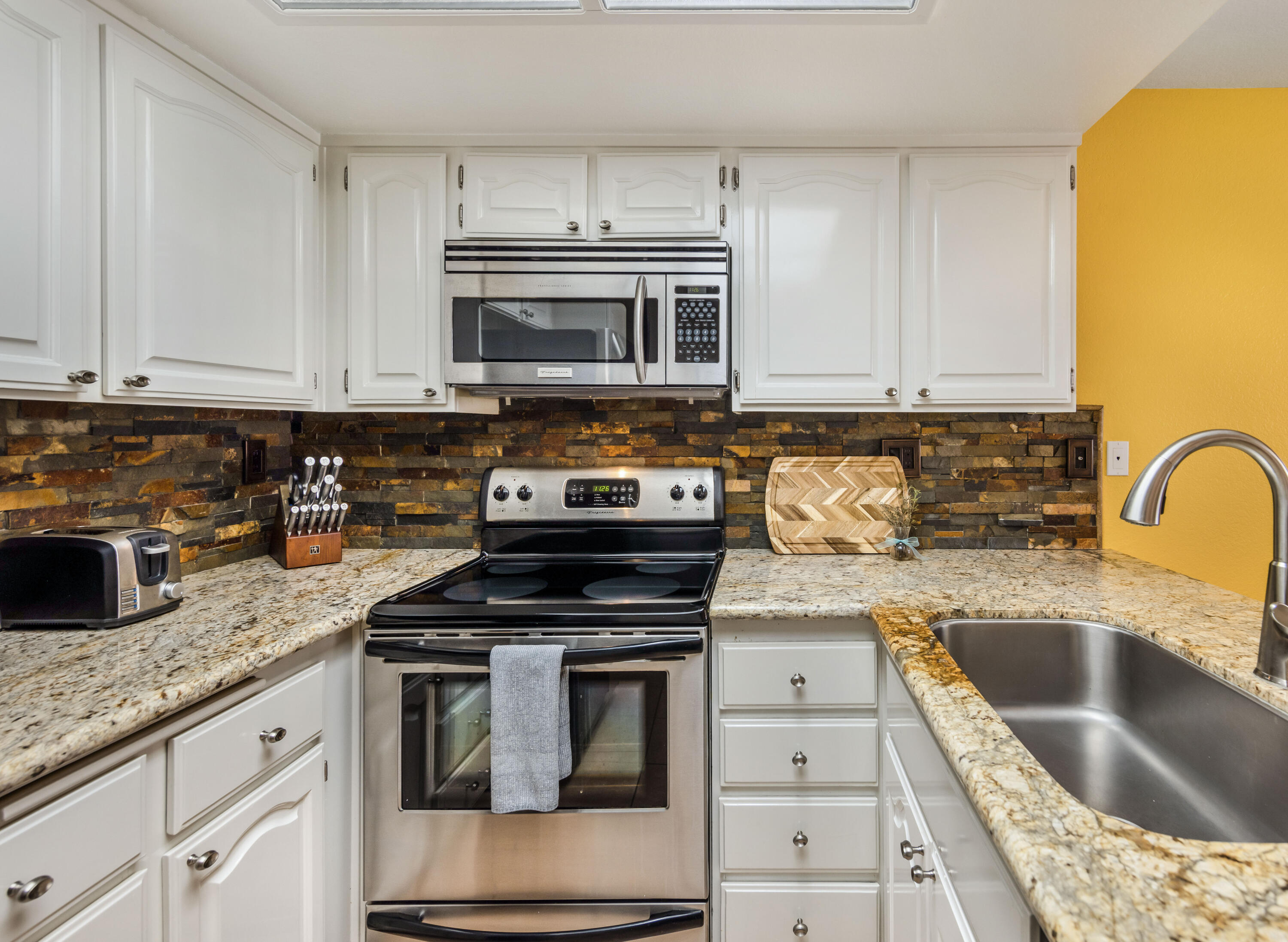 500 East Amado Road, Unit 512 Palm Springs, CA 92262 - Photo 10 of 37 a kitchen with granite countertop a sink stainless steel appliances and cabinets