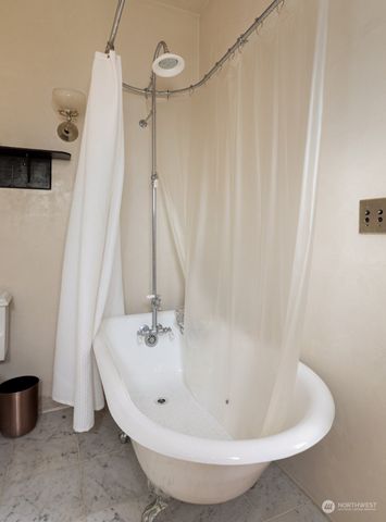 a bed sitting in a spacious bedroom next to a window