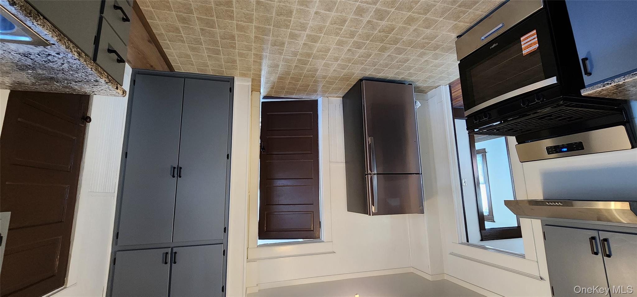 20 Delaware Street, Unit 1 Port Jervis, NY 12771 - Photo 4 of 12 Kitchen featuring range, fridge, gray cabinets, and exhaust hood