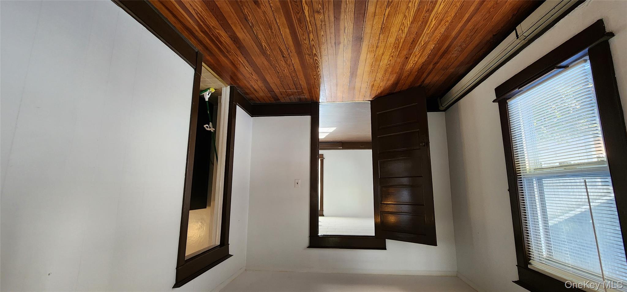 20 Delaware Street, Unit 1 Port Jervis, NY 12771 - Photo 5 of 12 Unfurnished room with a baseboard heating unit and dark wood-style floors