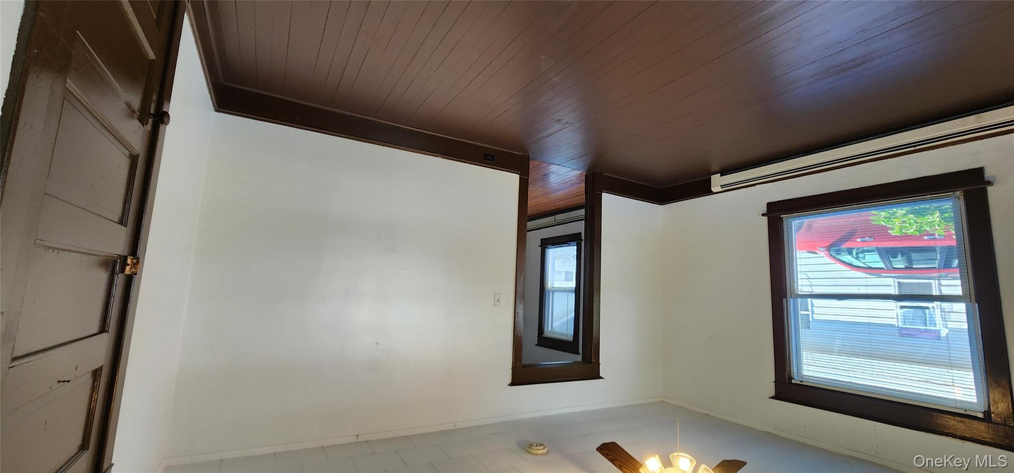 20 Delaware Street, Unit 1 Port Jervis, NY 12771 - Photo 6 of 12 Spare room featuring baseboard heating, dark wood finished floors, ornamental molding, and ceiling fan
