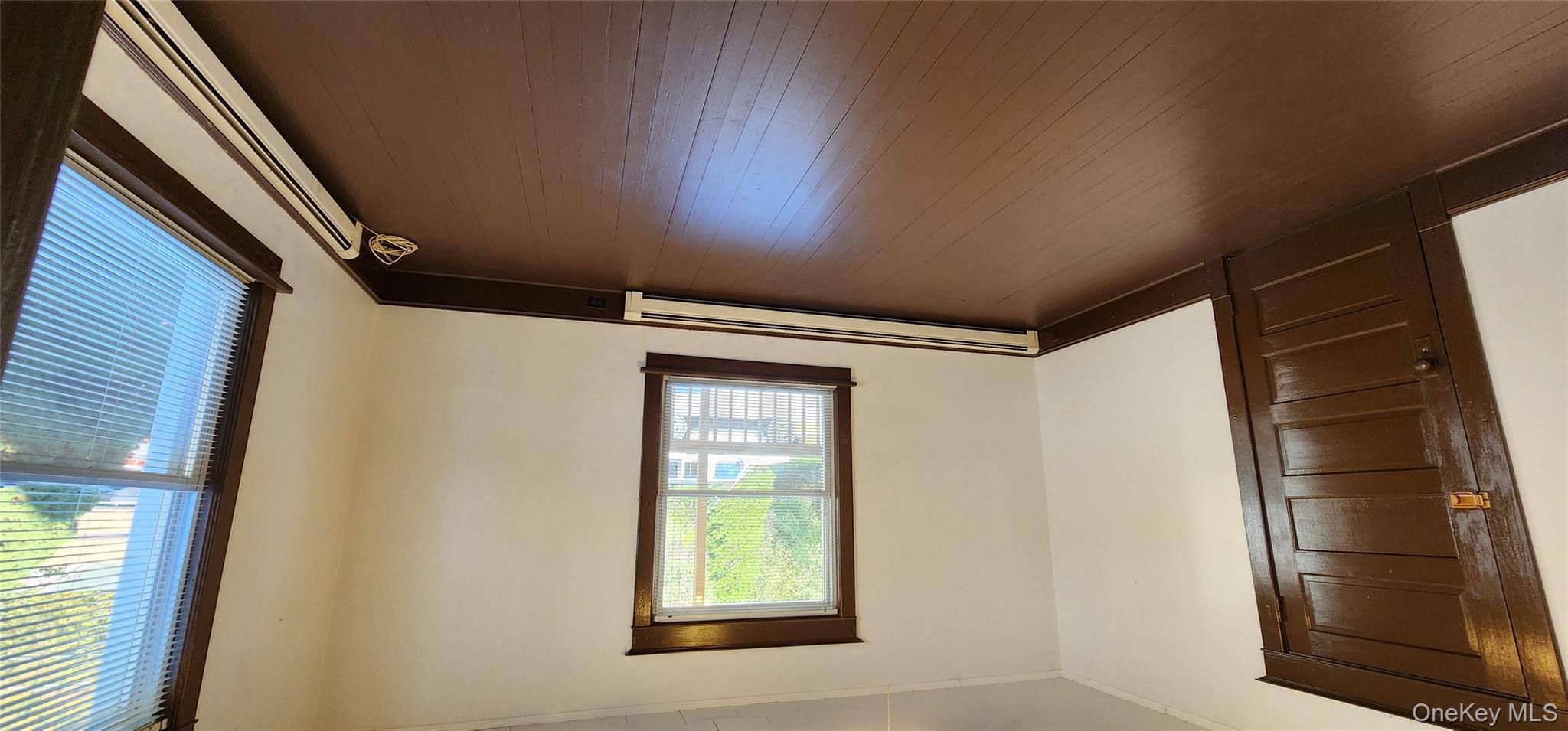 20 Delaware Street, Unit 1 Port Jervis, NY 12771 - Photo 7 of 12 Empty room featuring a baseboard radiator, dark wood-style floors, and crown molding