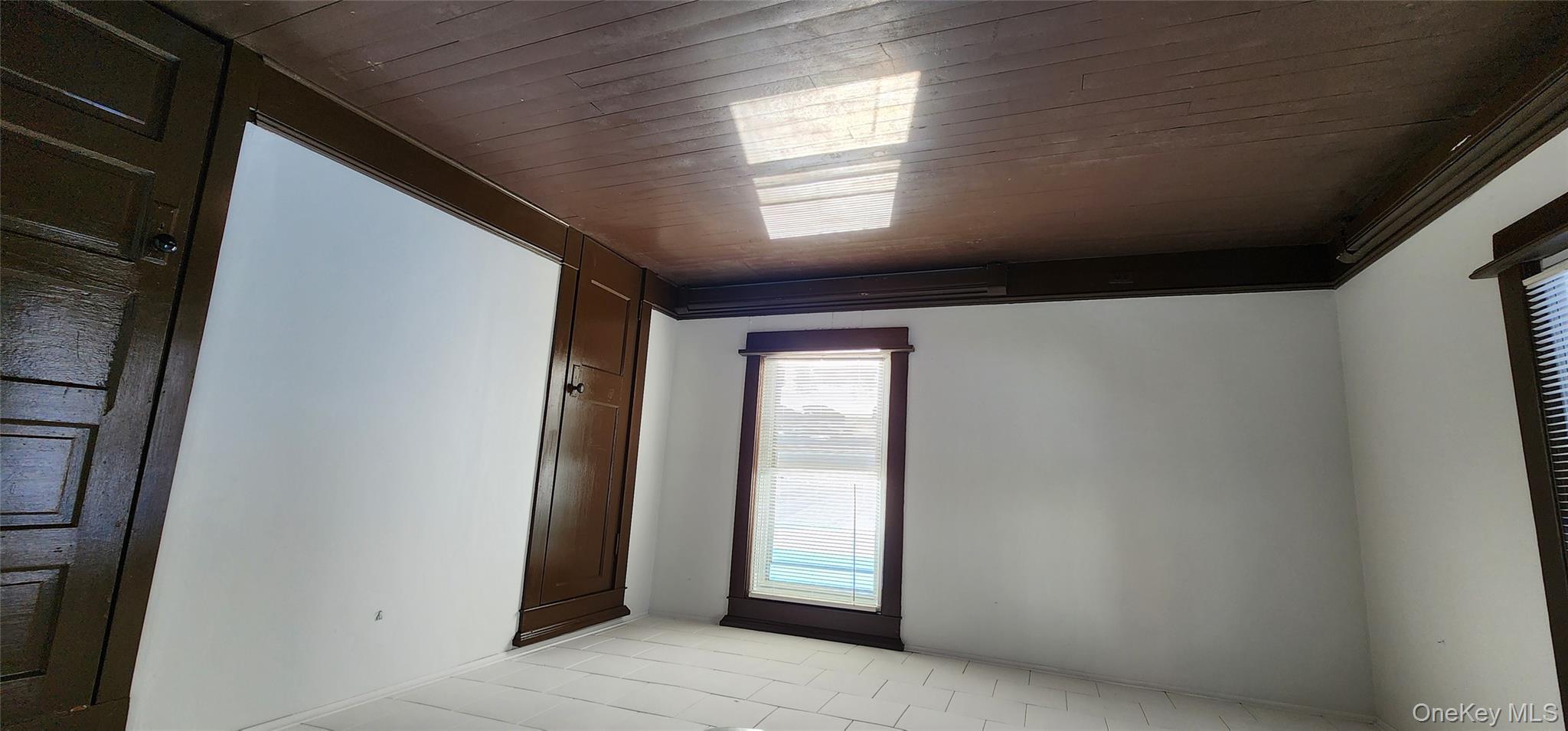 20 Delaware Street, Unit 1 Port Jervis, NY 12771 - Photo 9 of 12 Spare room featuring dark wood finished floors and baseboards