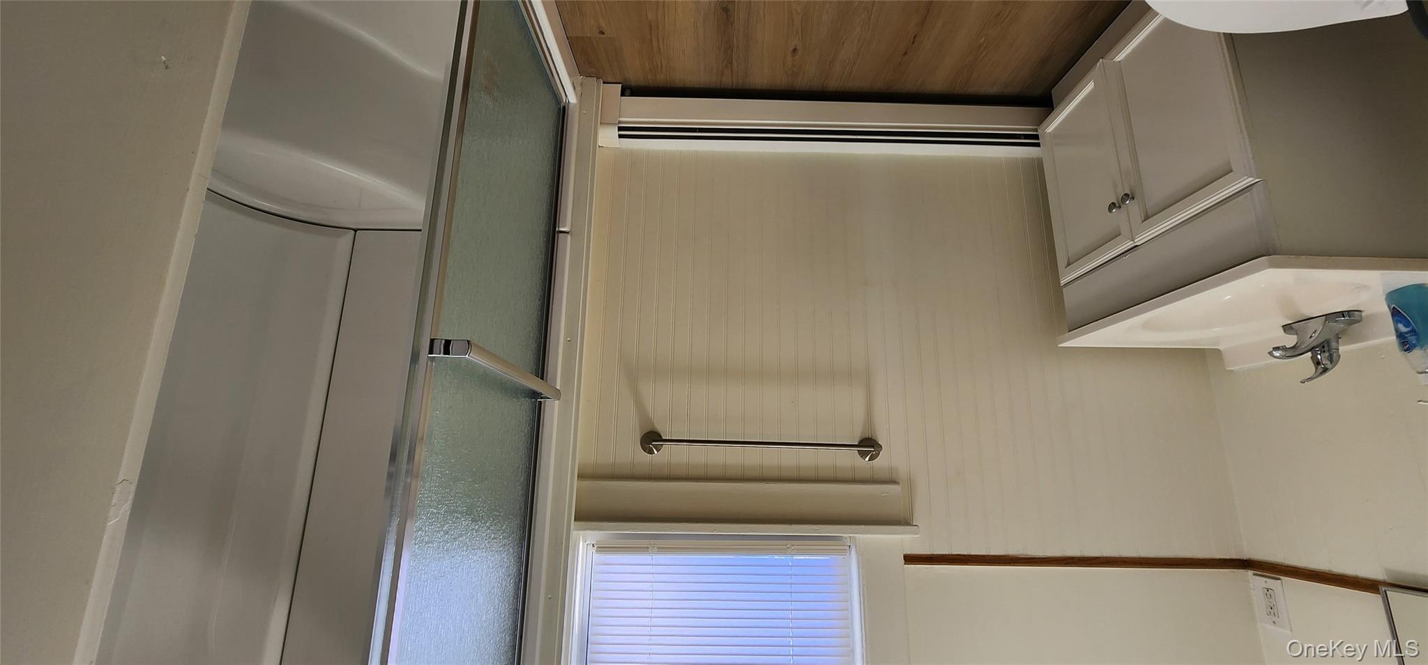 20 Delaware Street, Unit 1 Port Jervis, NY 12771 - Photo 10 of 12 Bathroom with vanity, a shower stall, dark wood-style floors, and a baseboard heating unit