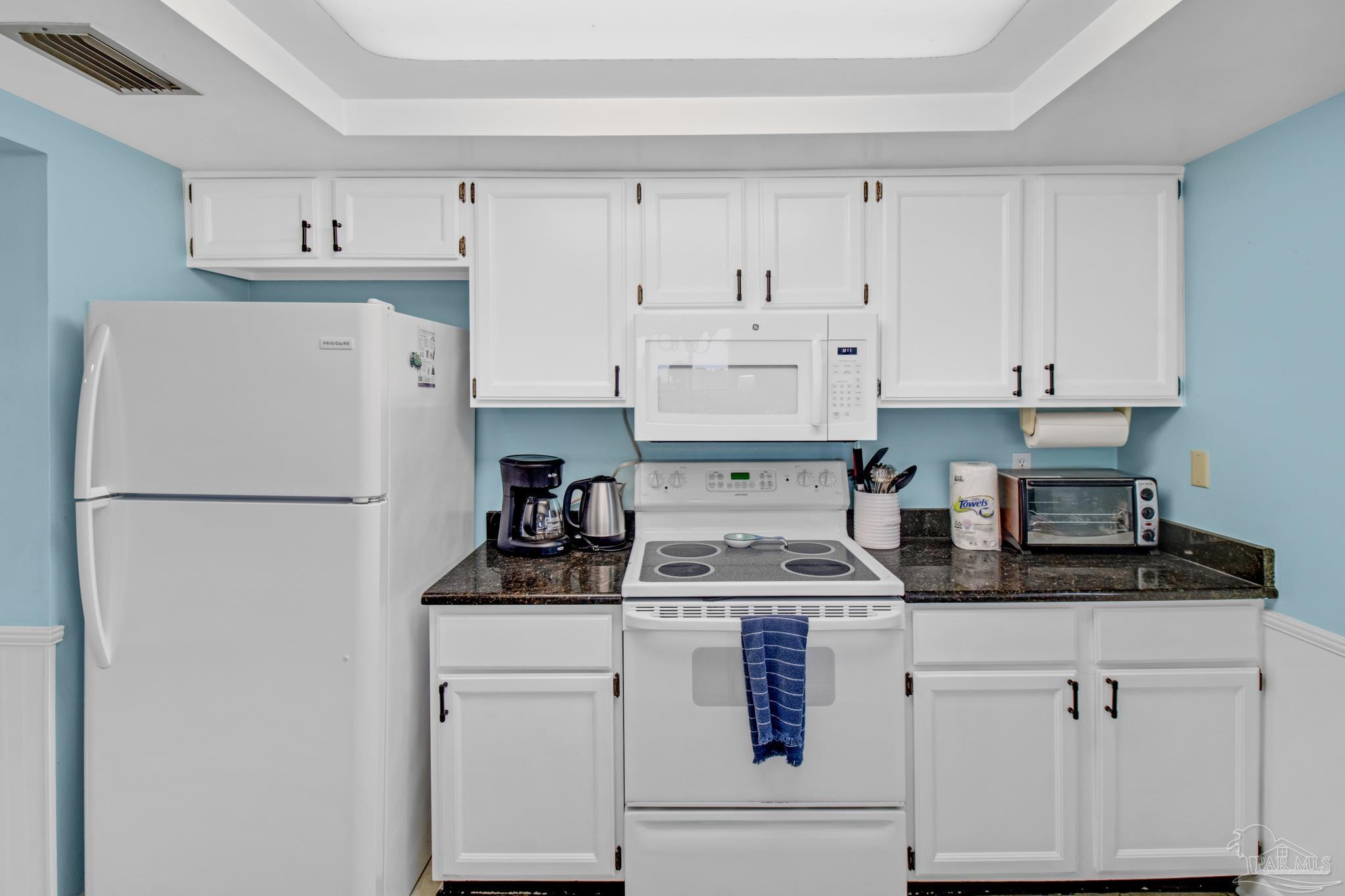 900 Fort Pickens Road, Unit 813 Pensacola Beach, FL 32561 - Photo 14 of 30 a kitchen with stainless steel appliances granite countertop white refrigerator stove and white cabinets