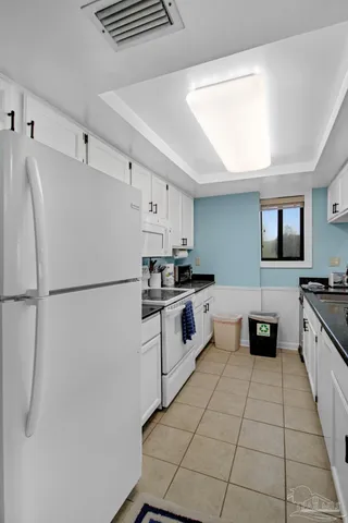 a kitchen with stainless steel appliances a refrigerator sink and white cabinets