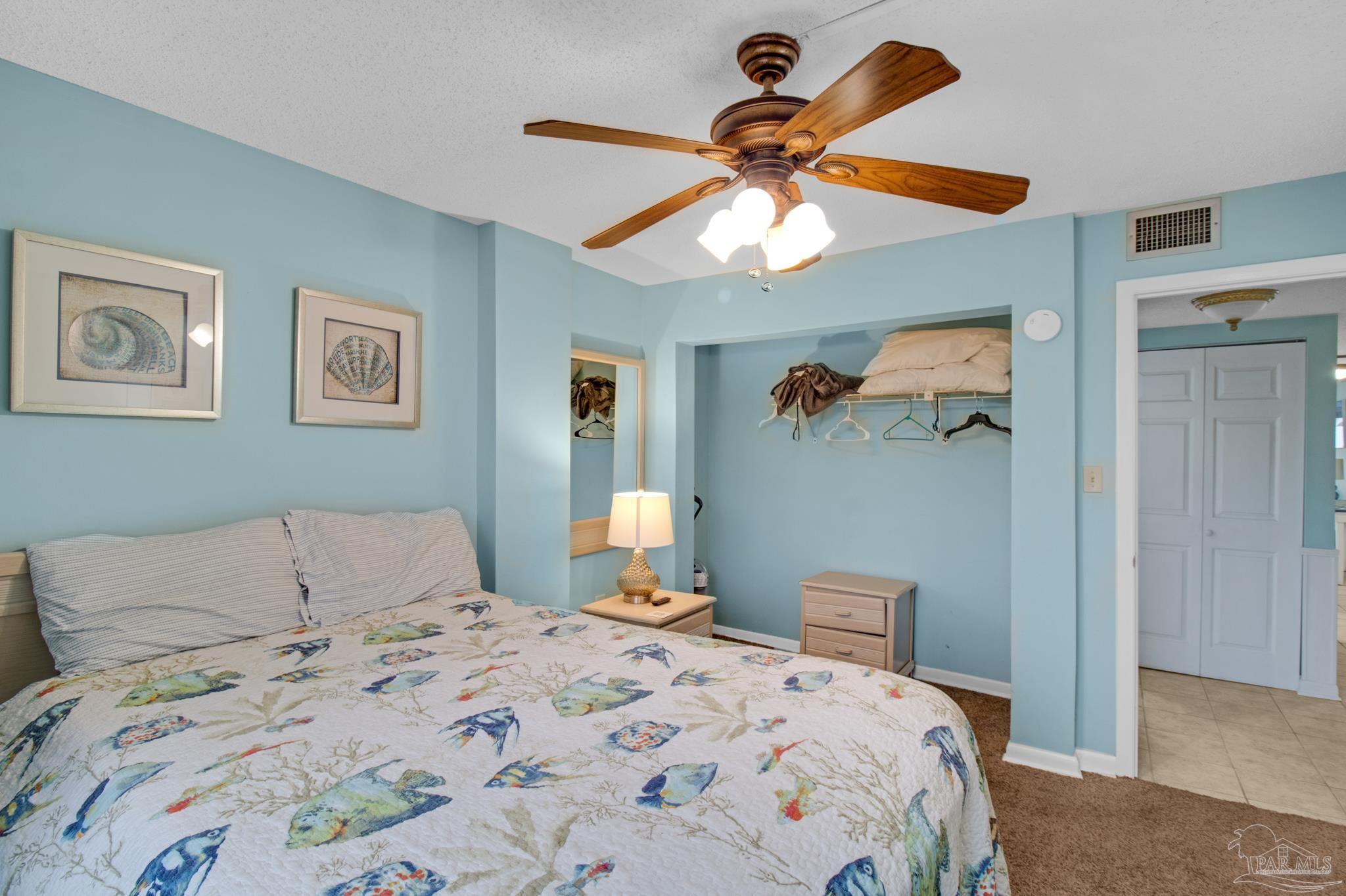 900 Fort Pickens Road, Unit 813 Pensacola Beach, FL 32561 - Photo 17 of 30 a bedroom with a bed and a chandelier