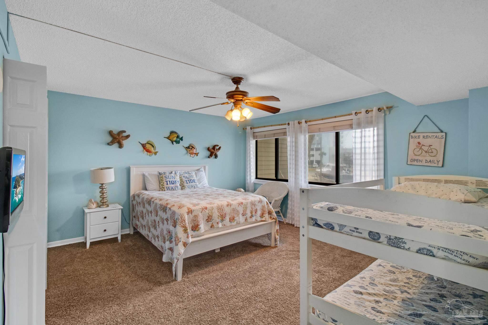 900 Fort Pickens Road, Unit 813 Pensacola Beach, FL 32561 - Photo 19 of 30 a bedroom with a bed and a chandelier