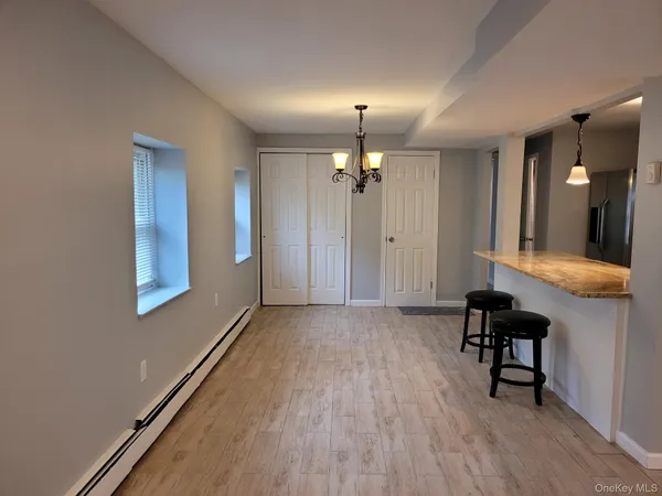a view of a hallway with wooden floor and furniture