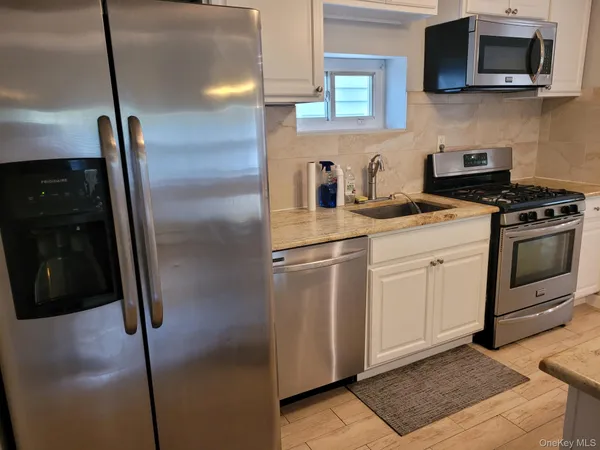 a kitchen with stainless steel appliances granite countertop a refrigerator a stove a sink and dishwasher