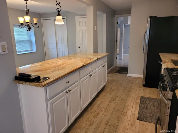 a spacious bathroom with a granite countertop sink a mirror and a shower