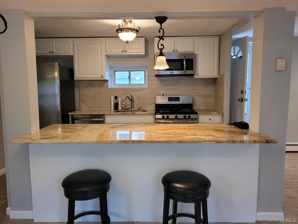 a kitchen with stainless steel appliances a sink a stove a refrigerator and cabinets