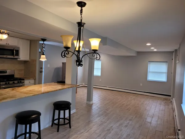 a view of a dining room with furniture a chandelier and wooden floor