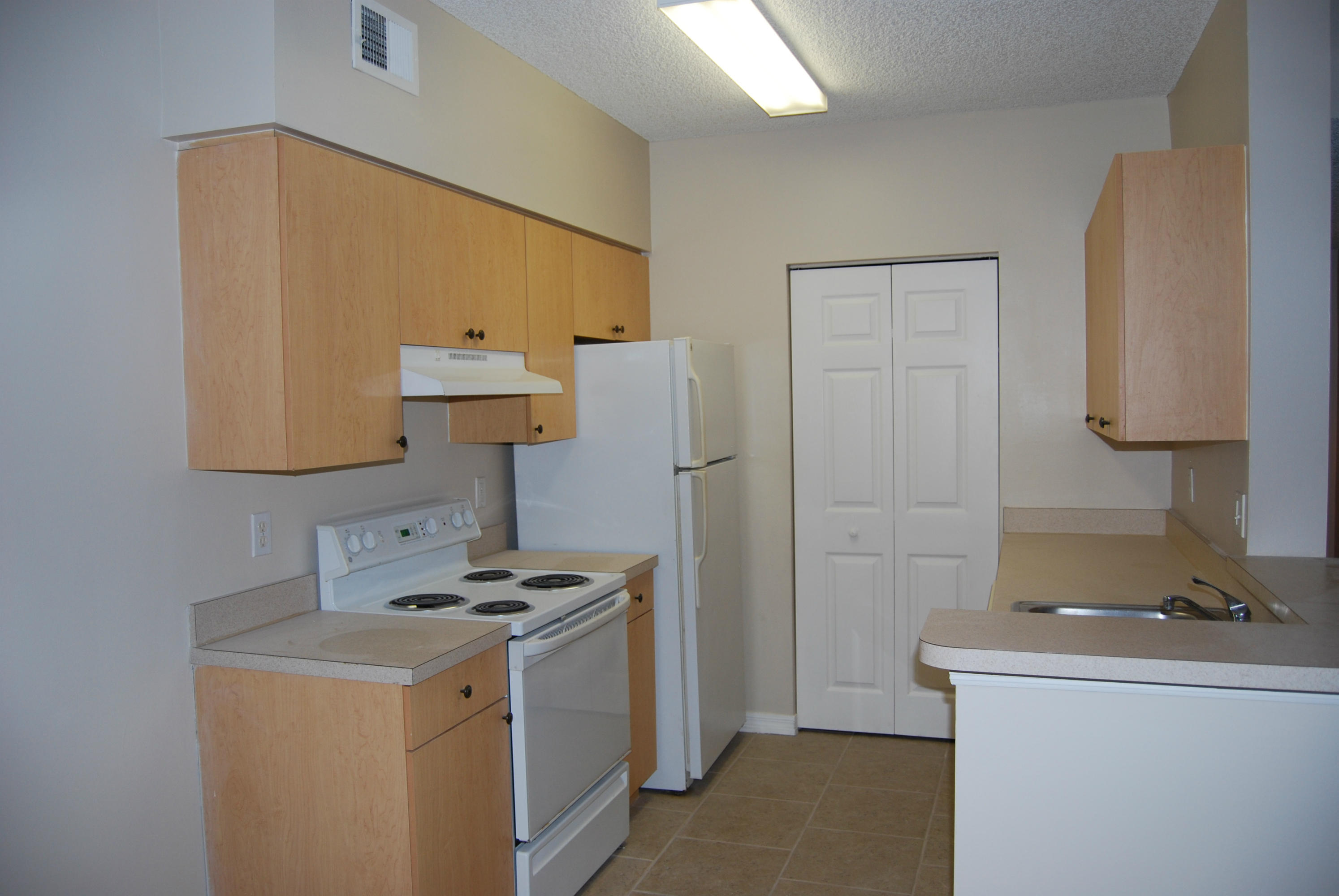 10336 Fox Trail Road South, Unit 1301 Royal Palm Beach, FL 33411 - Photo 3 of 8 a kitchen with a sink a stove and a refrigerator