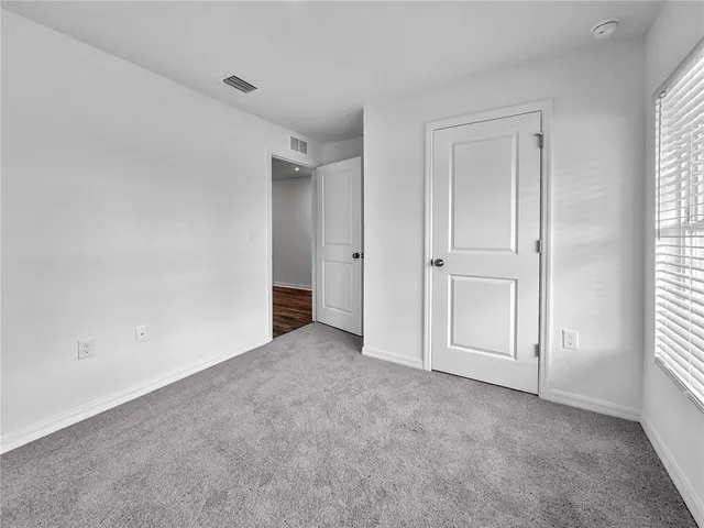 an empty room with windows and closet