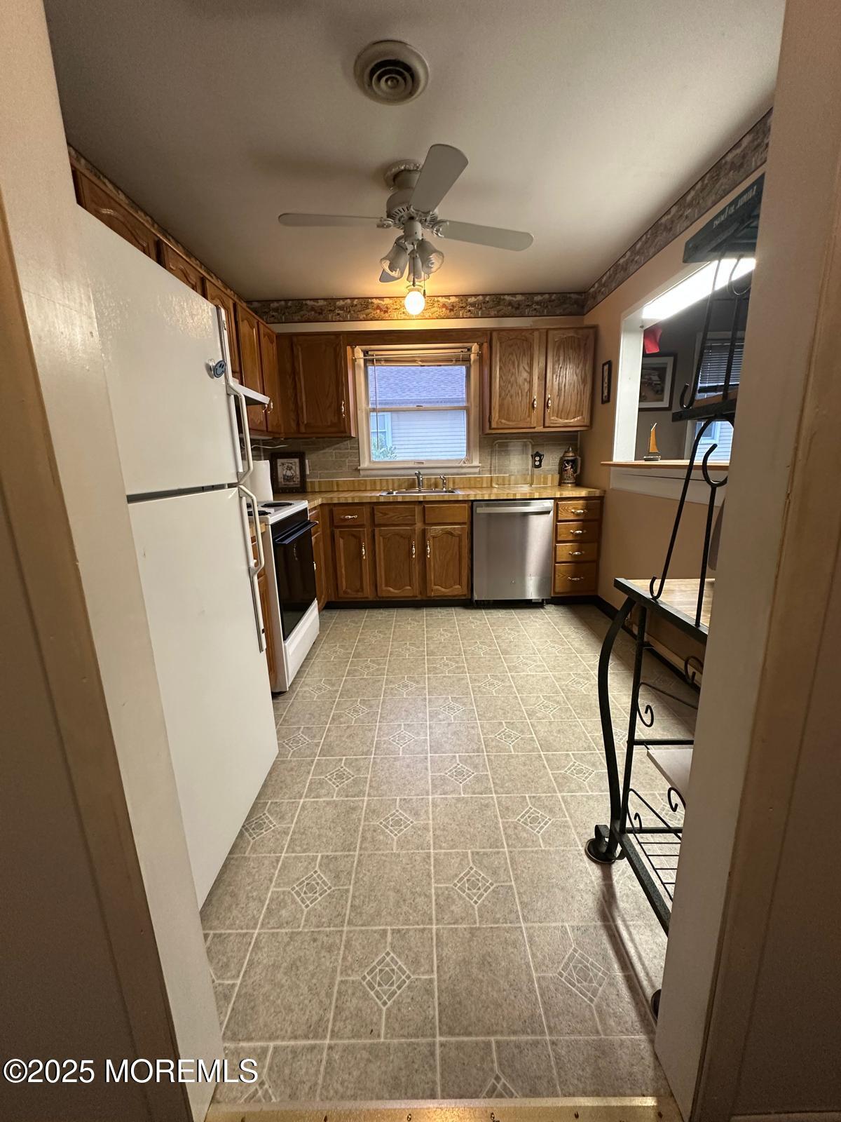 53 Sycamore Access Road Manahawkin, NJ 08050 - Photo 13 of 39 a kitchen with stainless steel appliances a refrigerator and a stove top oven