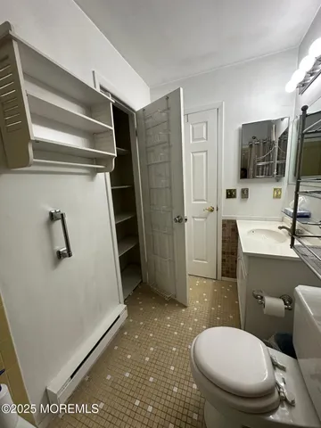 a bathroom with a sink a toilet a mirror and shower