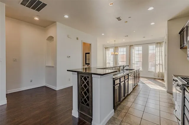 a kitchen with stainless steel appliances a stove top oven a sink and a refrigerator