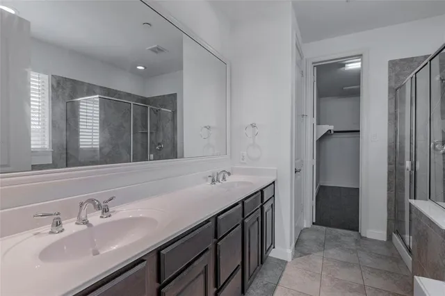 a spacious bathroom with a double vanity sink and a mirror