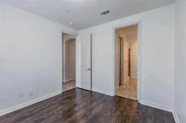 an empty room with wooden floor and closet