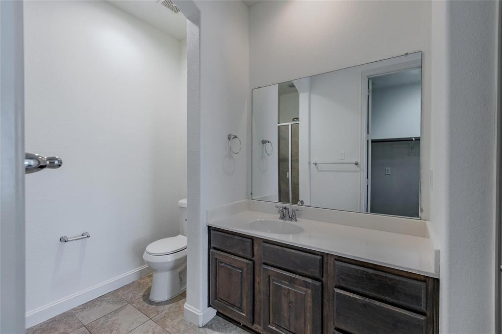 602 Arbol Irving, TX 75039 - Photo 6 of 38 a bathroom with a granite countertop toilet sink and mirror