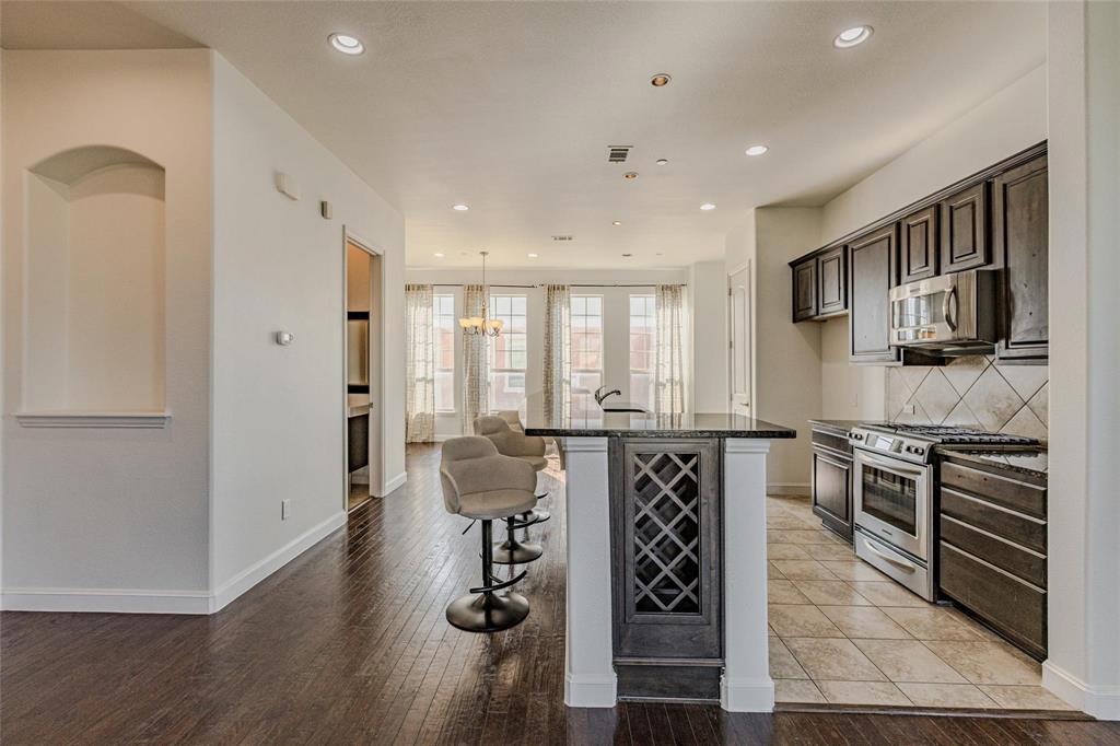 602 Arbol Irving, TX 75039 - Photo 10 of 38 a kitchen with stainless steel appliances granite countertop a stove top oven a sink a refrigerator white cabinets and wooden floor