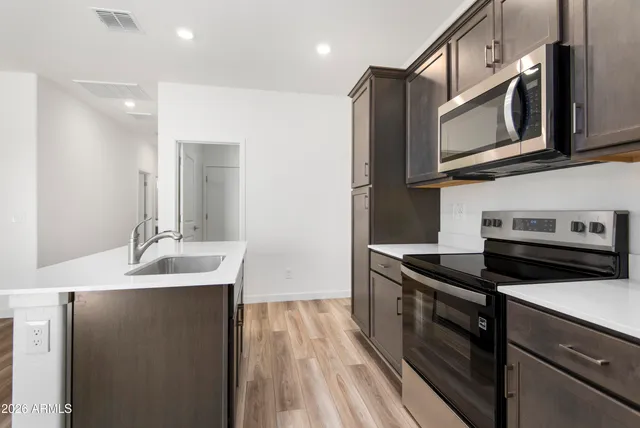 a kitchen with stainless steel appliances granite countertop a sink stove and microwave