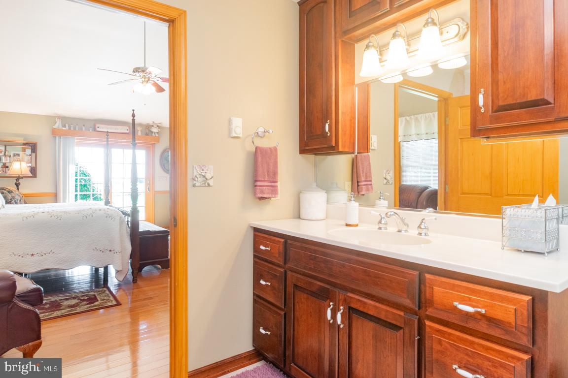 613 Hanover Pike Hampstead, MD 21074 - Photo 27 of 55 a en suite bathroom with a granite countertop sink and a large mirror next to a window
