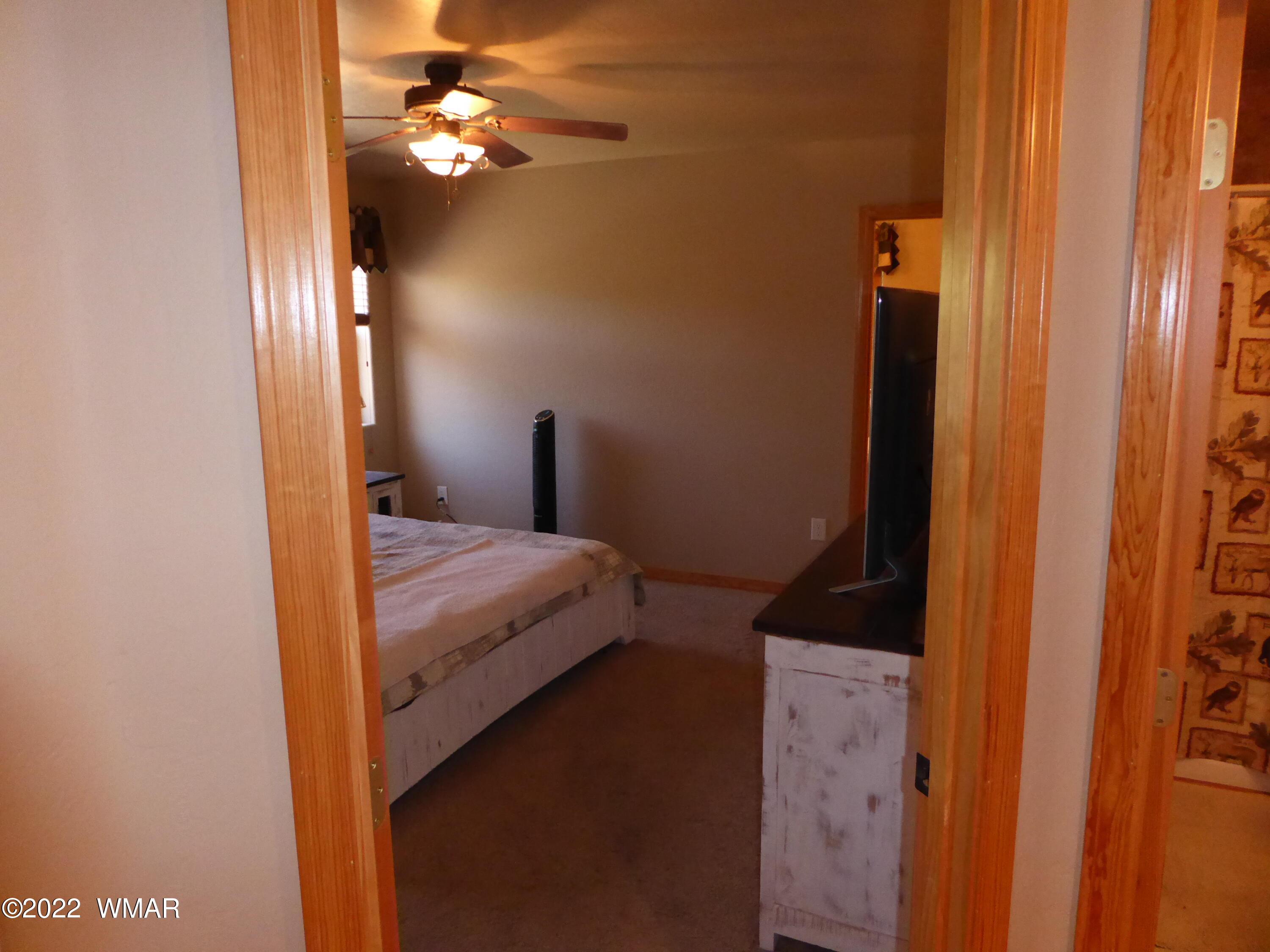 2953 Pine Rim Road Overgaard, AZ 85933 - Photo 10 of 32 a bedroom with a bed and a chandelier
