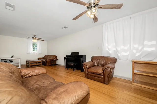 a living room with furniture ceiling fan and a rug