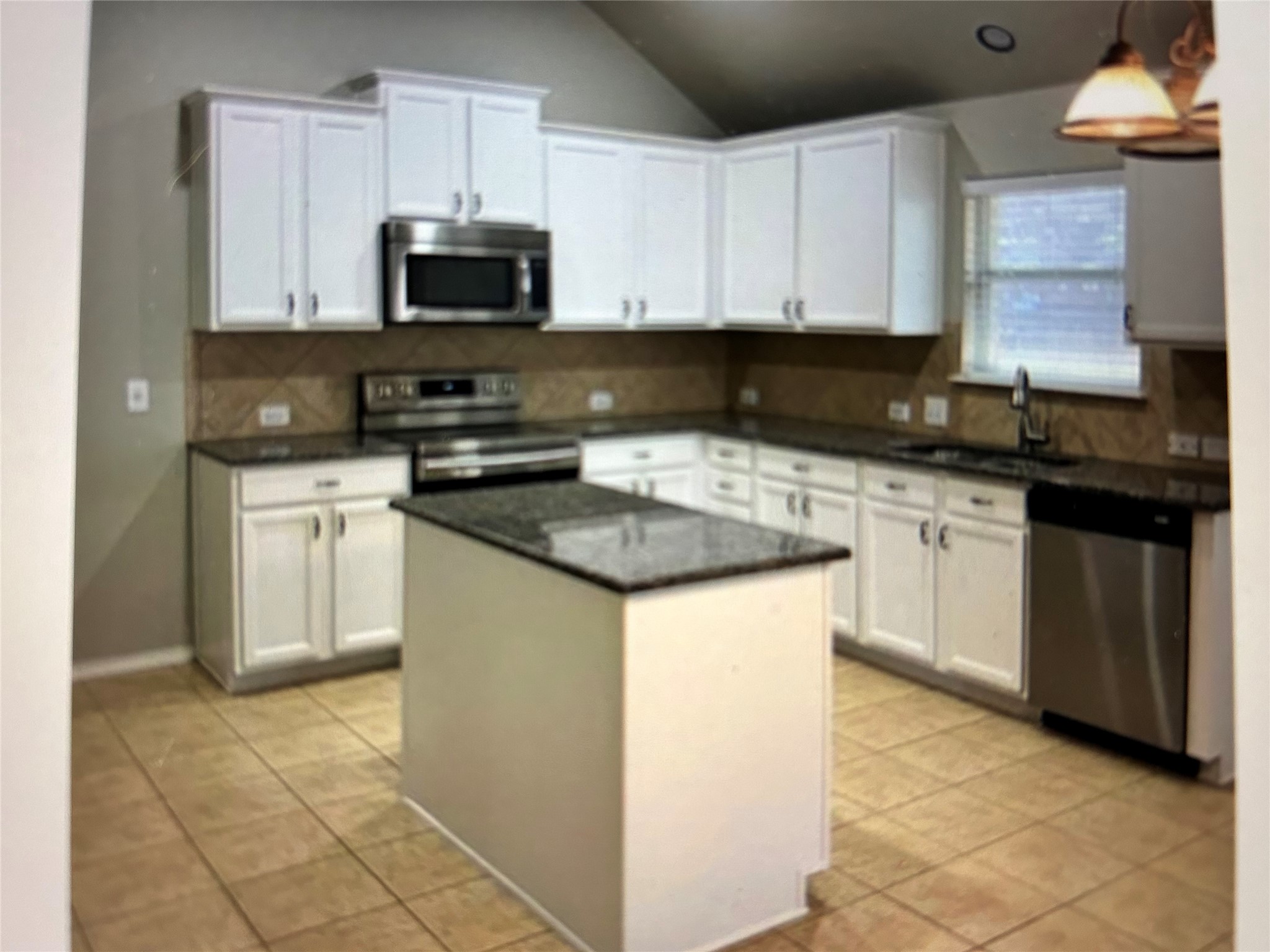 211 Animas Drive Georgetown, TX 78626 - Photo 4 of 25 a kitchen with stainless steel appliances granite countertop a stove a sink and a microwave