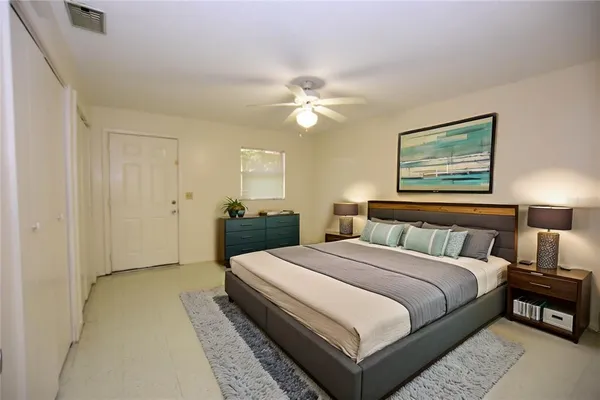 a spacious bedroom with a bed and a chandelier