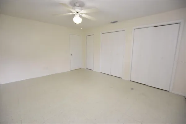 an empty room with a ceiling fan and a window