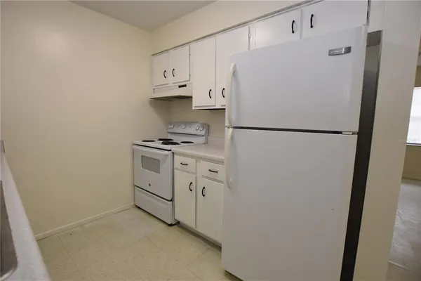 a white refrigerator freezer and a stove sitting inside of a kitchen