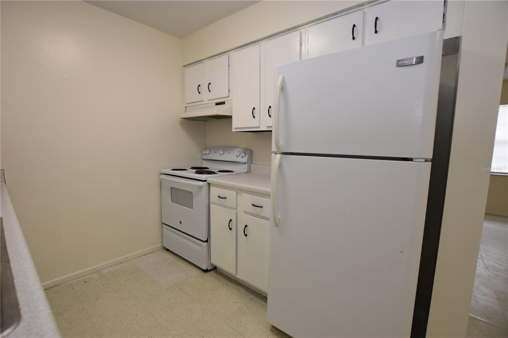 619 Robin Road, Unit 3 Lakeland, FL 33803 - Photo 3 of 17 a white refrigerator freezer and a stove sitting inside of a kitchen