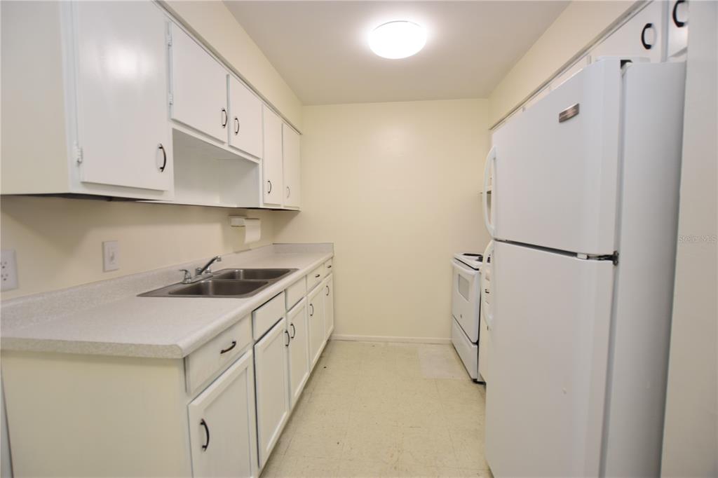 619 Robin Road, Unit 3 Lakeland, FL 33803 - Photo 4 of 17 a kitchen with a sink a refrigerator and cabinets
