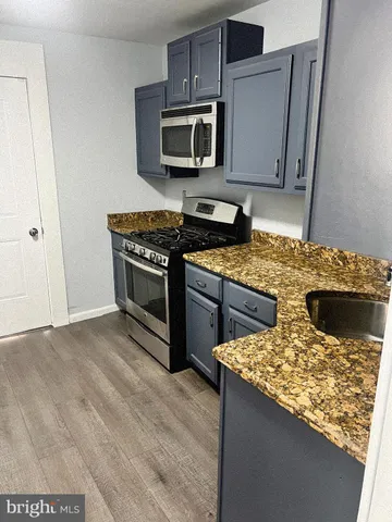 a kitchen with stainless steel appliances granite countertop a stove top oven microwave and refrigerator