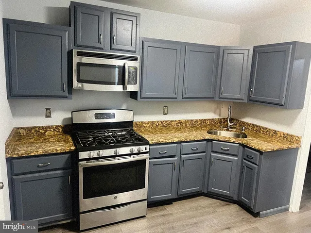 a kitchen with granite countertop wooden cabinets and stainless steel appliances