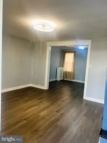 an empty room with wooden floor and mirror