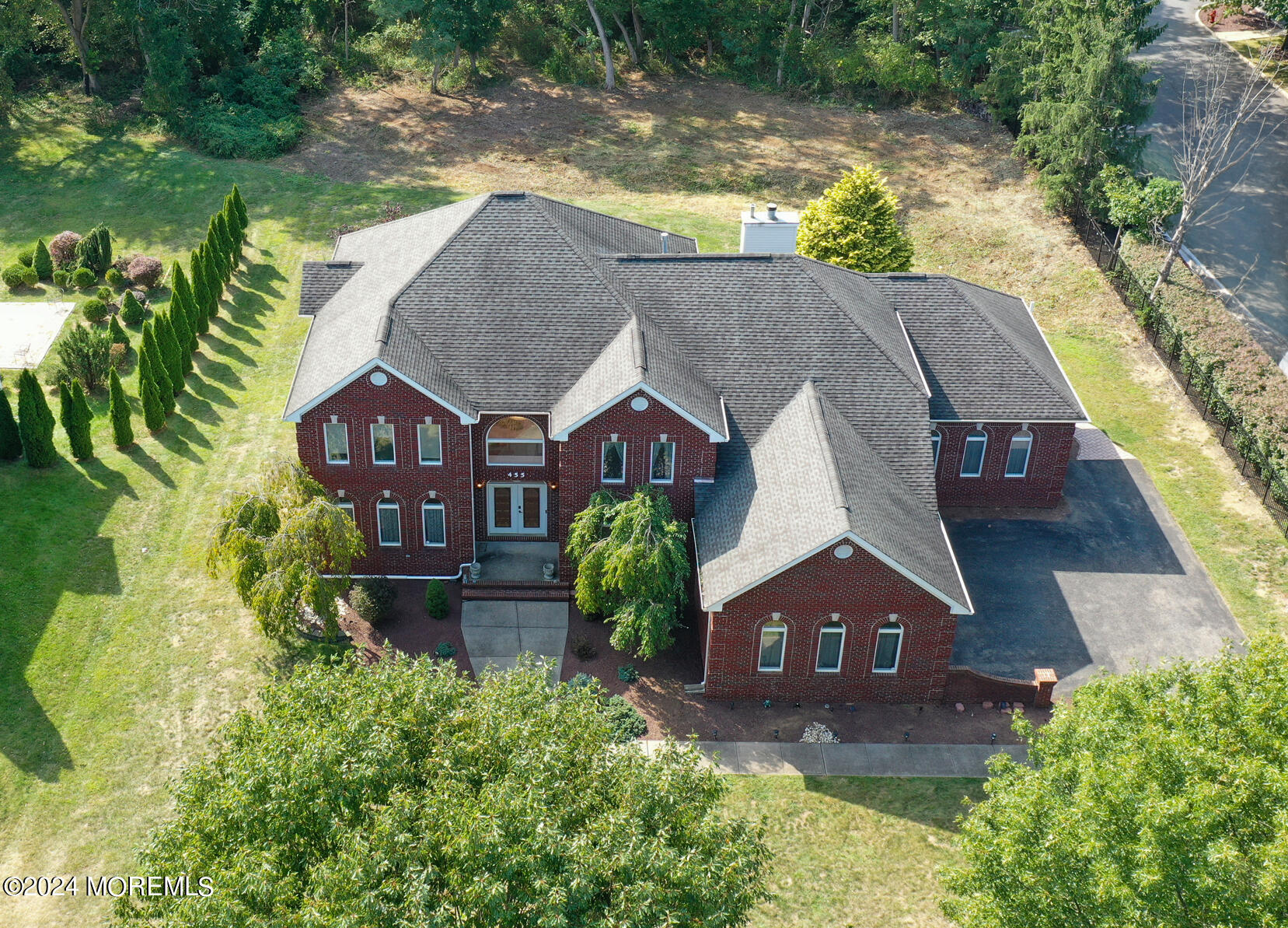 455 Iron Bridge Road Freehold, NJ 07728 - Photo 4 of 60 a aerial view of a house next to a yard with plants and large trees