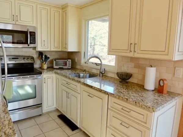 a kitchen with stainless steel appliances granite countertop a stove a sink and a microwave