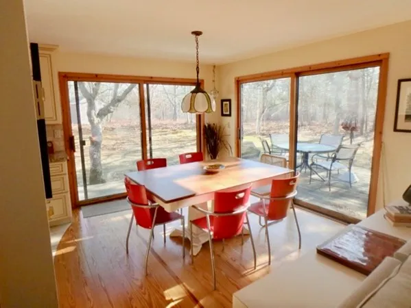 a dining room with furniture a chandelier and wooden floor